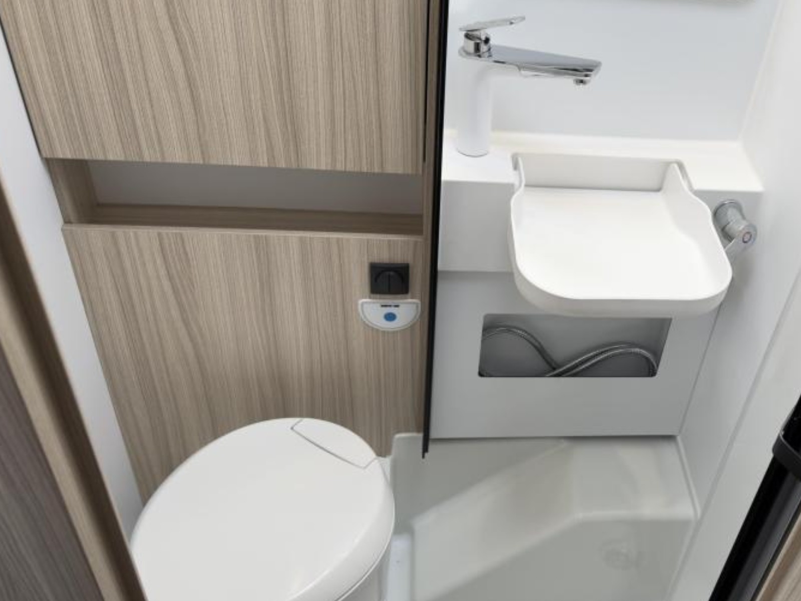 Compacte badkamer van de Sun Living S72DL camper met een wastafel, spiegel, toilet en douchecabine in een moderne, lichte afwerking